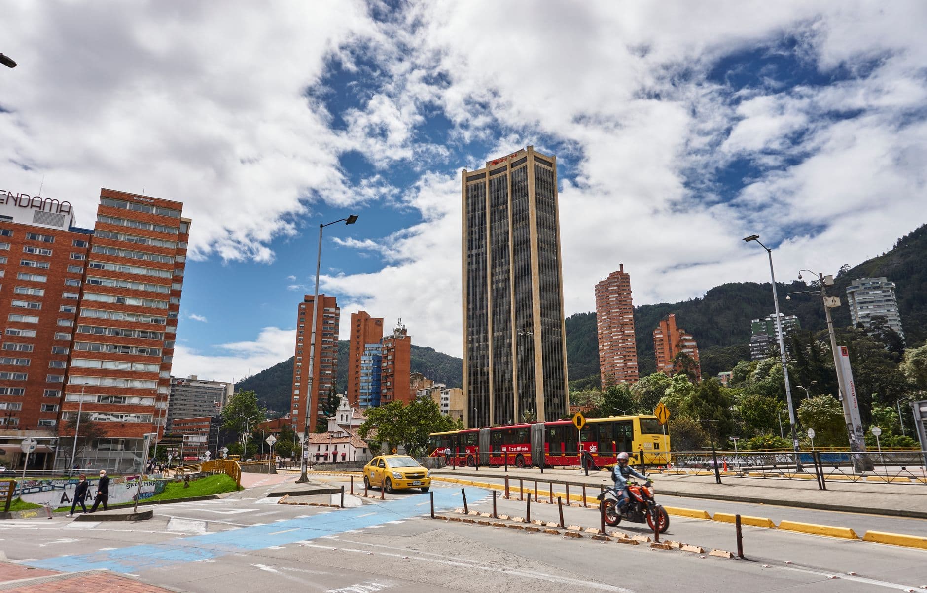Avenida de Bogotá con la Torre Colpatria, un bus de TransMilenio y un taxi